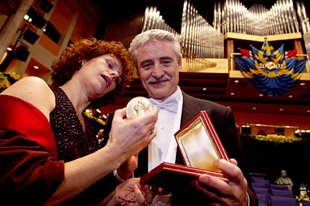 manbet手机版利兰·哈特韦尔教授向他的妻子展示他的诺贝尔奖奖章和文凭