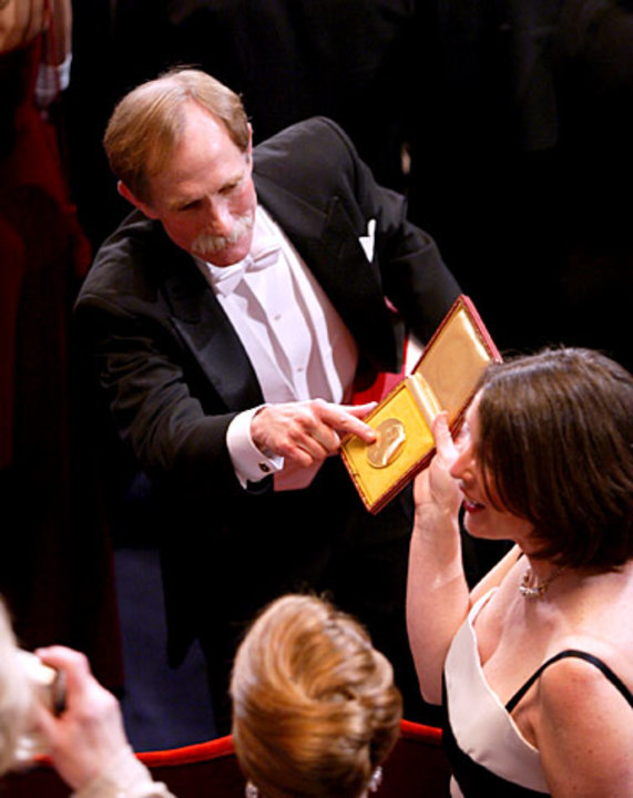 manbet手机版在斯德哥尔摩音乐厅举行的2003年诺贝尔奖颁奖典礼上，诺贝尔化学奖得主彼得·阿格雷向他的妻子展示他的奖章。