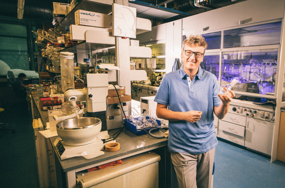 manbet手机版大卫·麦克米伦(David MacMillan)微笑着站在科学实验室里。