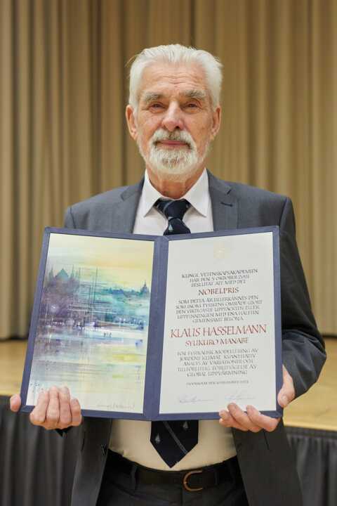 manbet手机版克劳斯·哈塞尔曼展示他的诺贝尔奖证书。