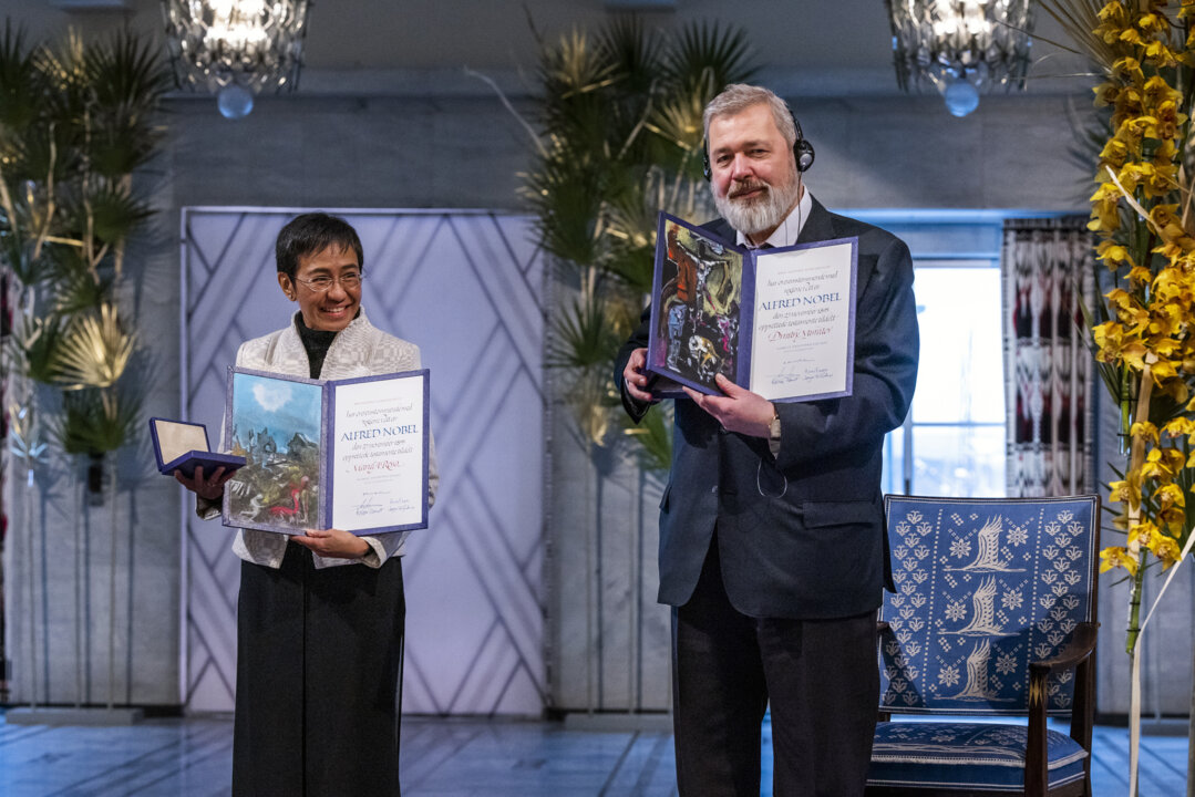 manbet手机版和平获奖者玛丽亚·瑞萨和德米特里·穆拉托夫展示他们的诺贝尔奖文凭