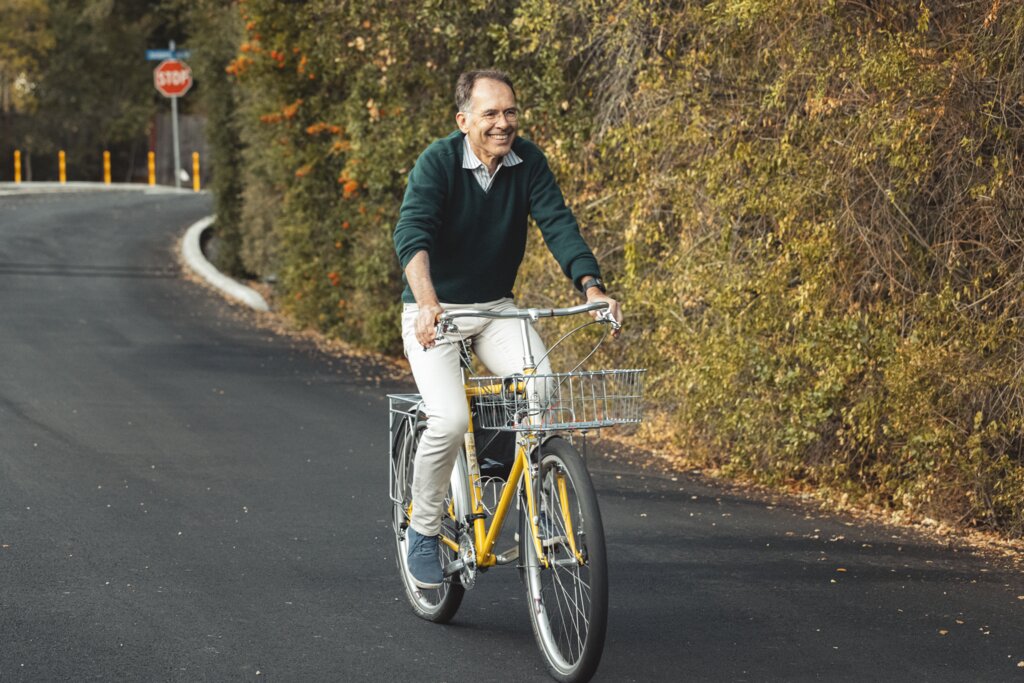 manbet手机版经济学奖得主圭多·因本斯(Guido Imbens)在一条绿树成荫的道路上骑着一辆黄色自行车