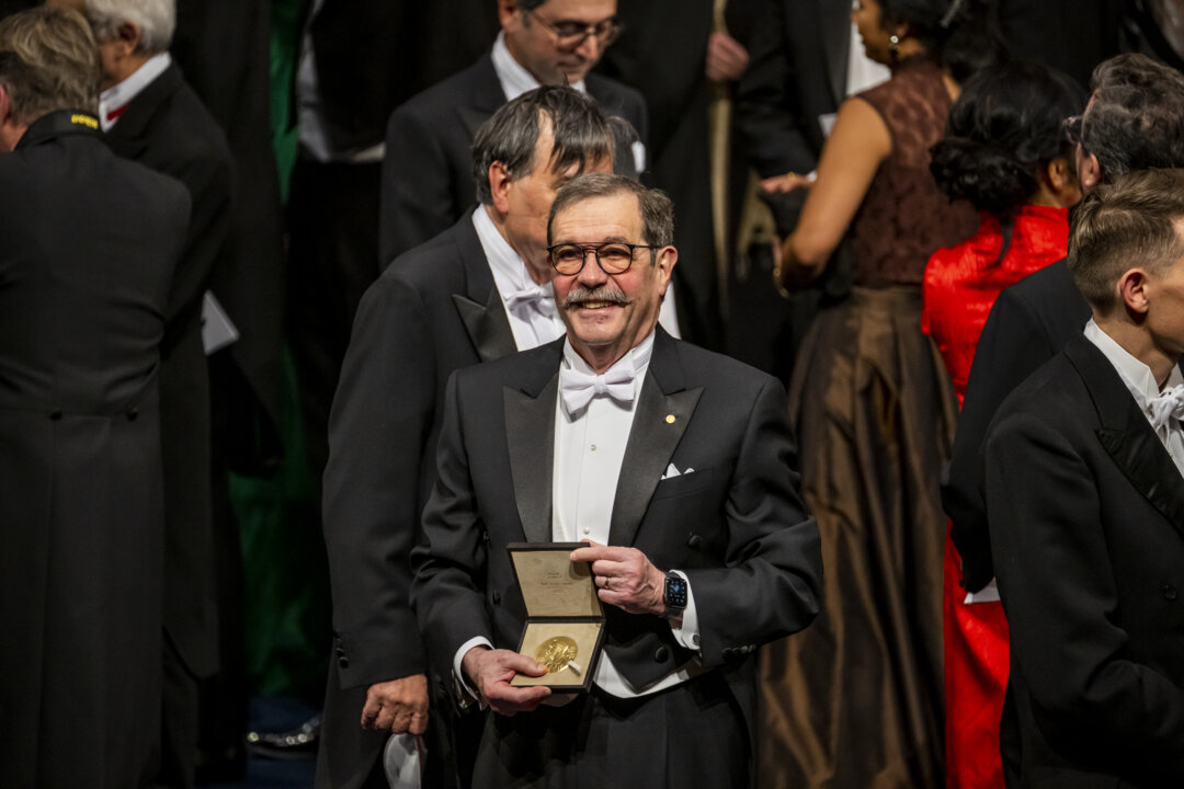 manbet手机版物理学奖得主Alain Aspect展示他的诺贝尔奖奖章
