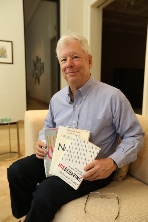 manbet手机版理查德·塞勒(Richard Thaler)和他的书合影。