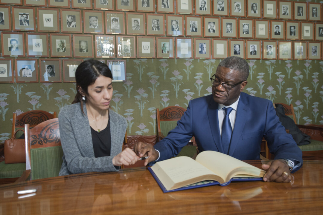 manbet手机版Nadia Murad和Denis Mukwege在留言簿上签名