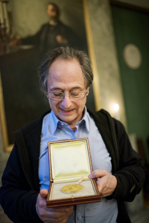 manbet手机版迈克尔·莱维特在访问诺贝尔基金会时展示他的诺贝尔奖章