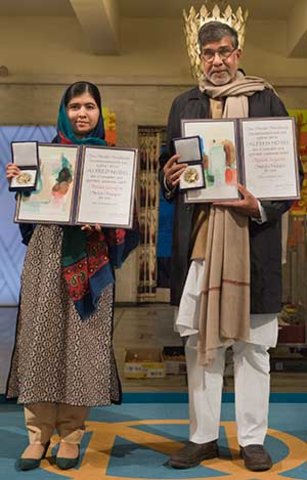 manbet手机版2014年12月10日，马拉拉·尤萨夫扎伊和冈拉什·萨蒂亚尔希在挪威奥斯陆市政厅举行的诺贝尔和平奖颁奖典礼上展示他们的诺贝尔奖章和文凭。