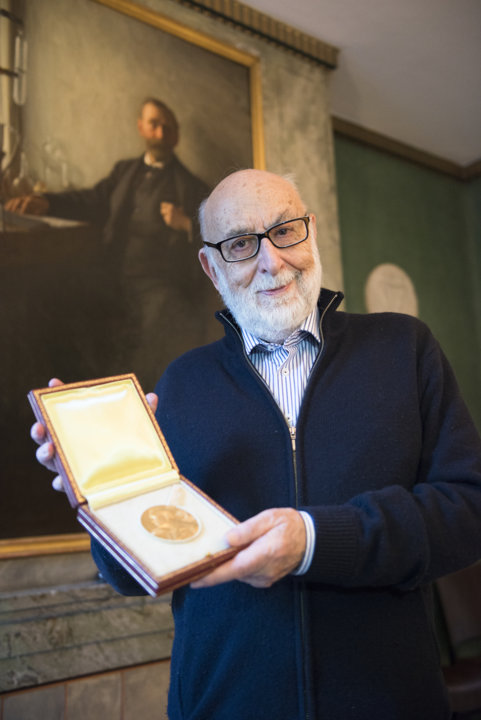 manbet手机版François恩格勒特在访问诺贝尔基金会时展示他的诺贝尔奖章