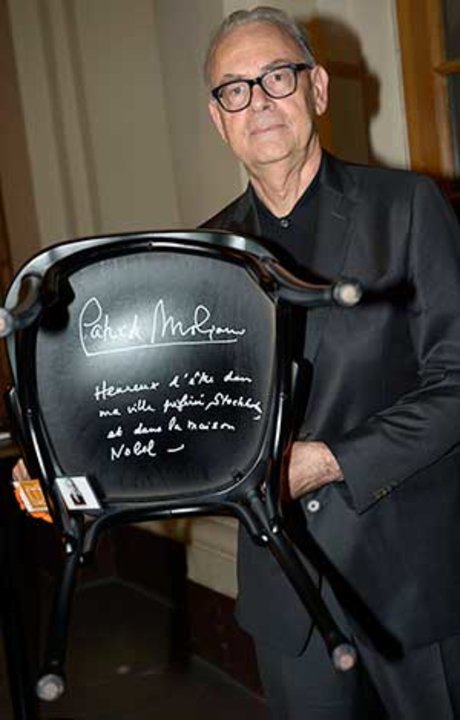 manbet手机版2014年12月6日，斯德哥尔摩诺贝尔博物馆，帕特里克·莫迪亚诺(Patrick Modiano)在诺贝尔小酒馆的一把椅子上签名。