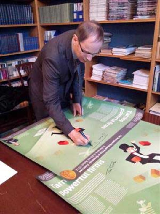 At the Royal Swedish Academy of Sciences, Jean Tirole autographs posters explaining his awarded work.