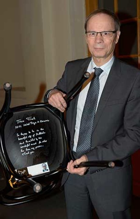 Like many Laureates before him, Jean Tirole autographs a chair at Bistro Nobel at the Nobel Museum in Stockholm, 6 December 2014.