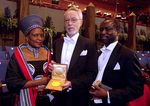 manbet手机版诺贝尔文学奖得主约翰·m·库切(中)。manbet手机版南非驻瑞典大使桑托·库乔(左)和她的丈夫约翰·库乔博士(右)在斯德哥尔摩音乐厅举行的2003年诺贝尔奖颁奖典礼后合影。