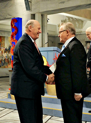 manbet手机版挪威国王哈拉尔五世(左)与诺贝尔和平奖得主马尔蒂·阿赫蒂萨里握手