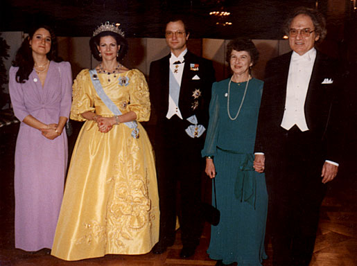 manbet手机版瑞典女王西尔维娅，身着耀眼的黄色长袍，站在卡尔十六世古斯塔夫国王身旁，与赫伯特·a·豪普特曼和他的家人合影
