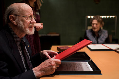 manbet手机版威廉·c·坎贝尔在访问诺贝尔基金会期间仔细查看了他的诺贝尔证书。