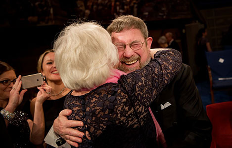 manbet手机版Berit Kosterlitz夫人给了她的丈夫，物理学桂冠获得者J. Michael Kosterlitz一个拥抱