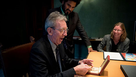 manbet手机版2016年12月12日，让-皮埃尔·索维奇在访问诺贝尔基金会期间仔细查看了他的诺贝尔奖章。