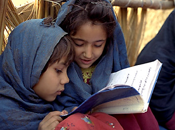 manbet手机版两个女孩共用一本教科书。manbet手机版＂width=