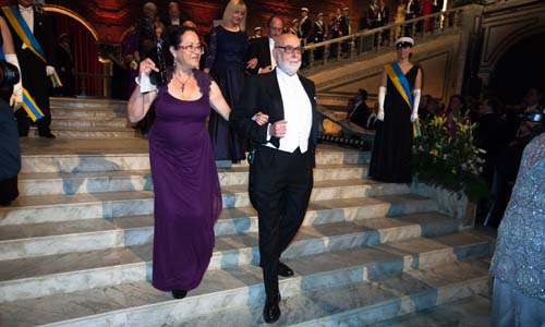 manbet手机版François恩格勒与化学奖得主迈克尔·莱维特的配偶丽娜·莱维特一起进入蓝色大厅。