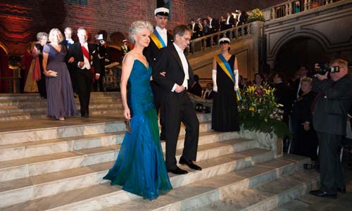 manbet手机版2013年12月10日，拉尔斯·彼得·汉森和安娜·玛丽亚·科拉扎·比尔特走下楼梯，前往斯德哥尔摩市政厅蓝色大厅的诺贝尔晚宴。