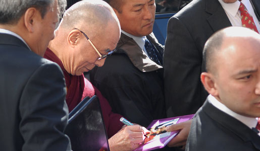 manbet手机版达赖喇嘛为博物馆参观者签名。