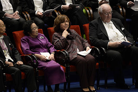 manbet手机版诺贝尔奖得主坐在舞台上。manbet手机版从左起:医学获奖者Satoshi Å mura和屠呦呦，文学获奖者Svetlana Alexievich和经济学获奖者Angus Deaton。