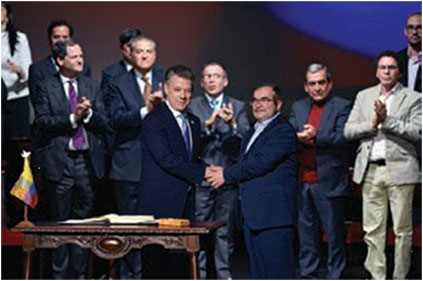 manbet手机版总统桑托斯,罗德里戈Londono和双方的谈判代表庆祝最终和平协议的签名。