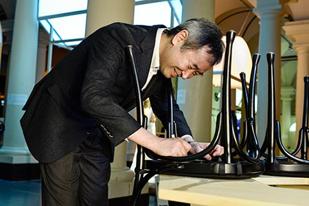 manbet手机版像之前的许多诺贝尔奖得主一样，在斯德哥尔摩诺贝尔博物馆的诺贝尔小酒馆(Bistro Nobel)的椅子上签名。