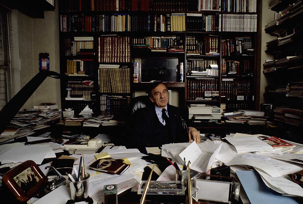 manbet手机版作家、哲学家和人文主义者埃利·威塞尔在他的办公桌前